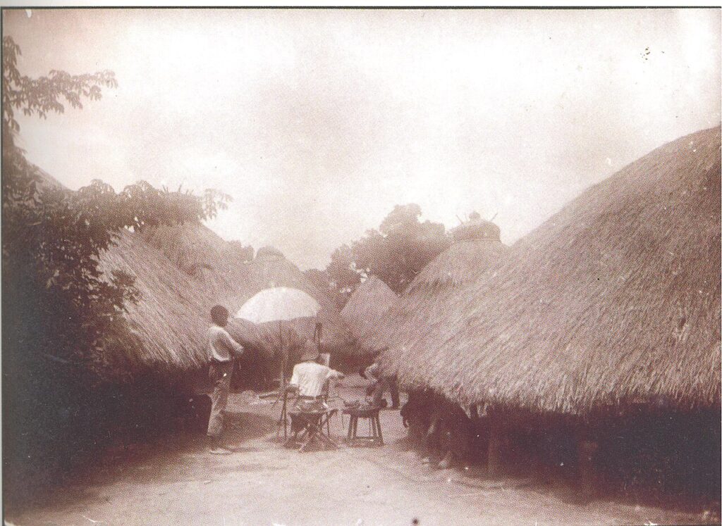 A rural village landscape in Benue State, Nigeria, with traditional buildings and farmland under an open sky.