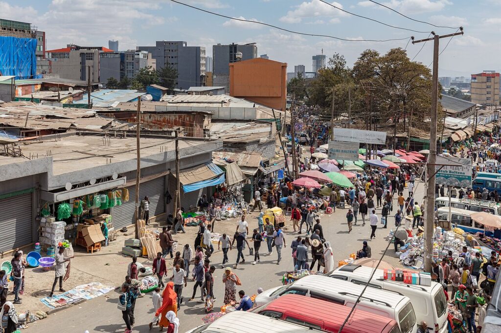 A government administrative building in Addis Ababa, Ethiopia, with people gathered outside during late afternoon.