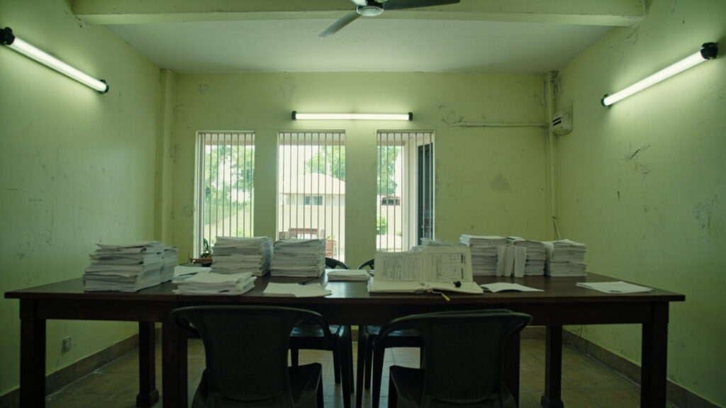 An empty municipal office in Port-au-Prince with a table prepared for voter registration, papers and an open ledger laid out under fluoresce