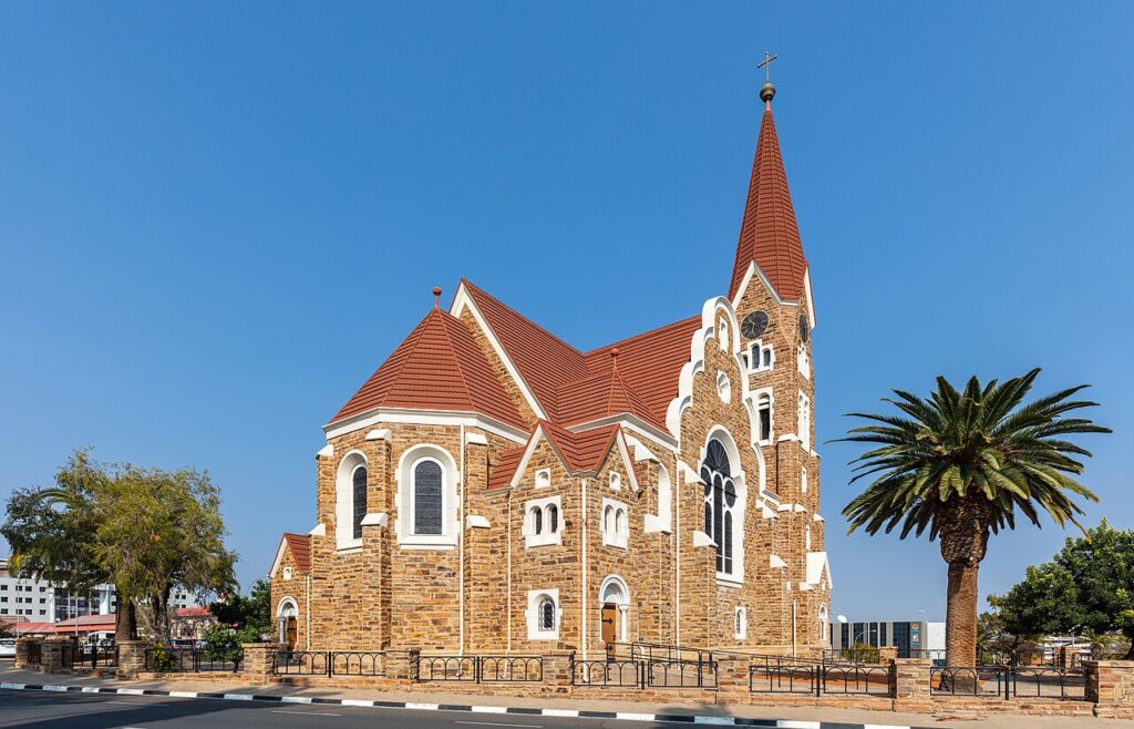 A wide-angle view of Windhoek's modern city centre with mid-rise government and commercial buildings set against the surrounding hills of ce