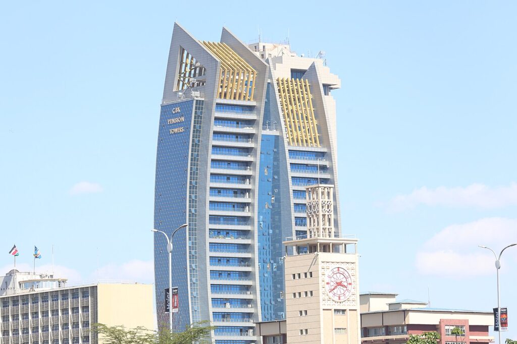A wide daytime view of a modern high-rise business district in an East African capital, with office towers, traffic and pedestrians visible