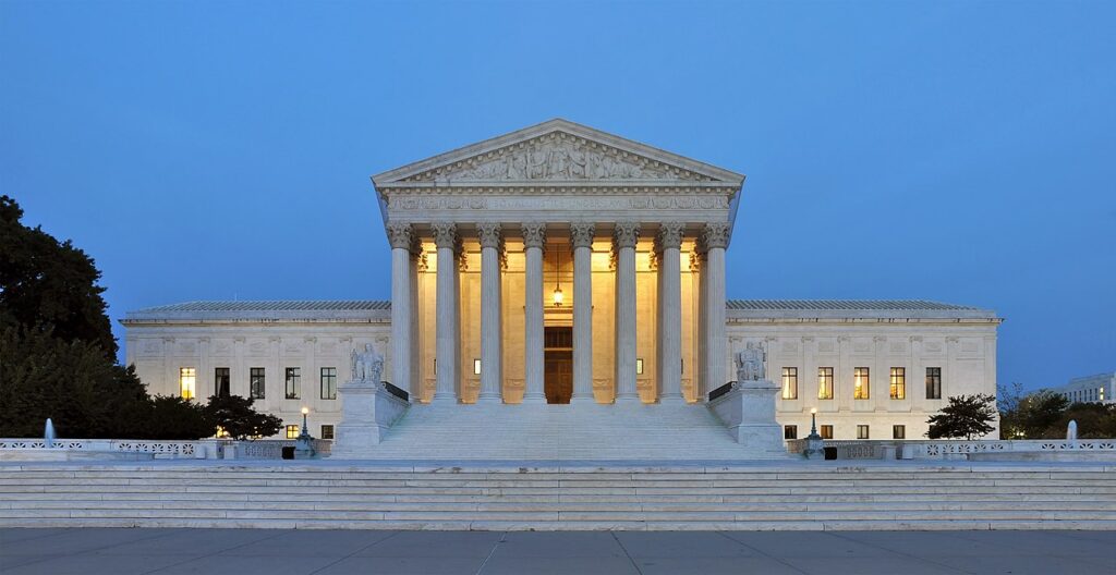 The neoclassical facade of a US federal court building with tall stone columns and marble steps under daylight.